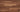 Close-up of Stikwood Reclaimed Natural peel-and-stick wood planks showing warm honey grain tones and rich wood texture — no sealing required
