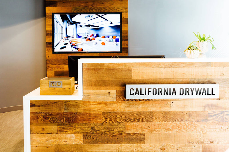 California Drywall reception desk faced with varied wood planks