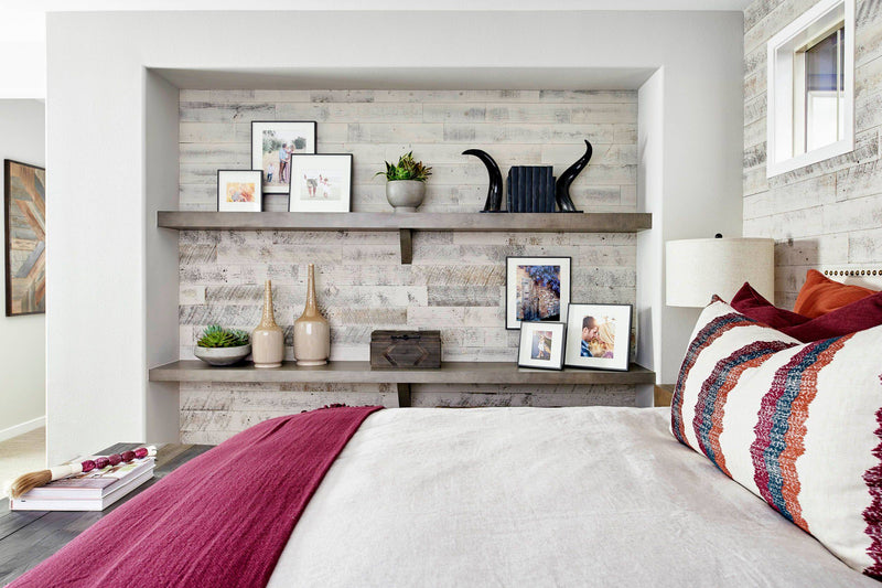 Bedroom with floating shelves on pale weathered wood walls