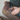 Close-up of hands holding a natural wood plank with visible grain and texture for a peel and stick project