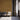 Waiting room with caramel-colored wood plank wall and three gray upholstered chairs