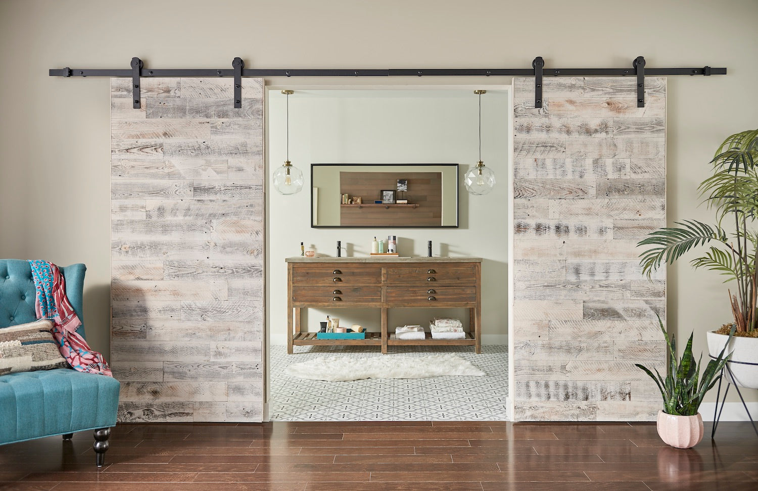 Sliding barn doors with whitewashed wood planks separating a living space and bathroom with natural light and plants