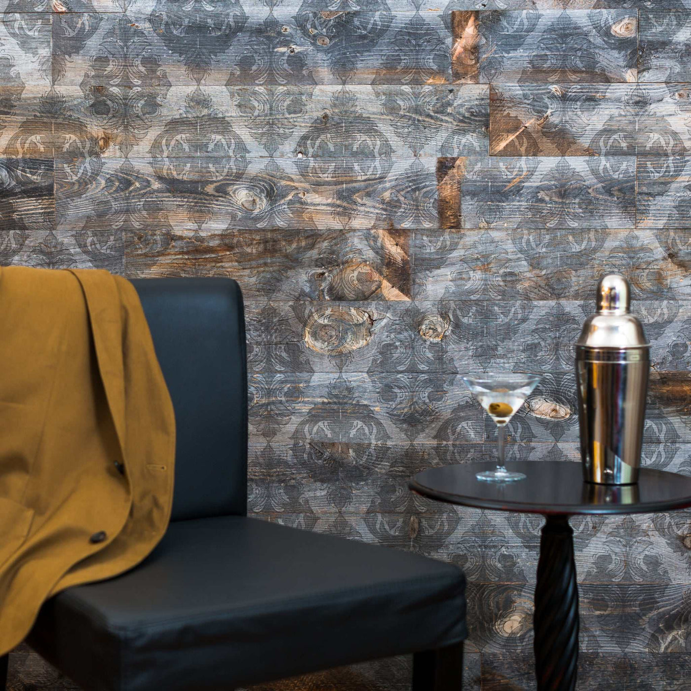 Victoria Peel & Stick Wood Wall Planks behind a chair, table, and cocktail