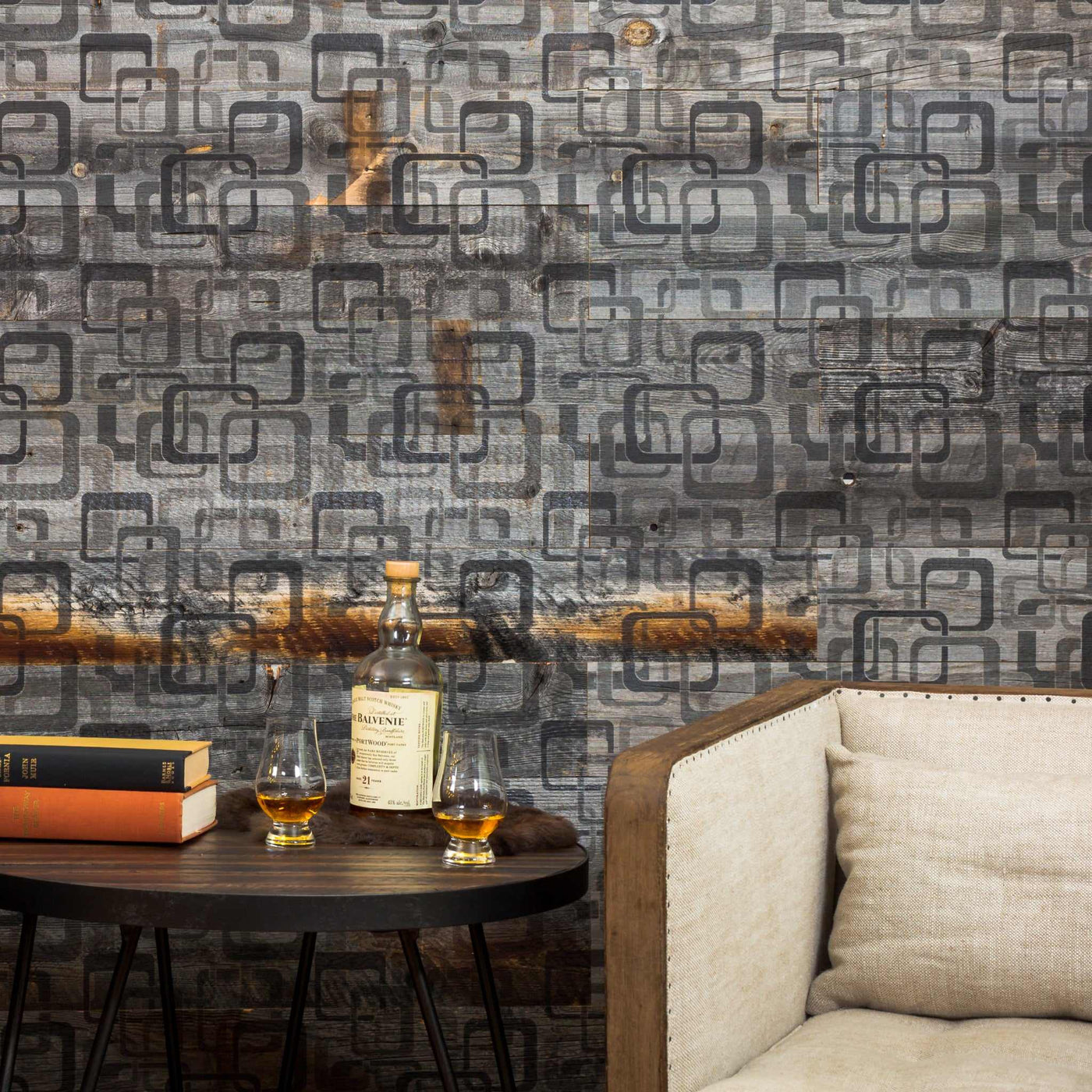 Weathered Mod Squad planks on a wall behind a side table with books and a drink