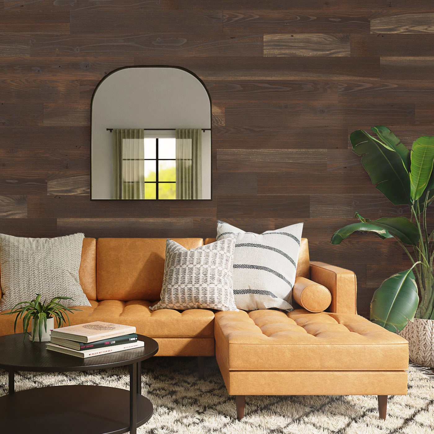 Living room with Woodland Dusk planks, tan couch, black mirror, and tropical plant