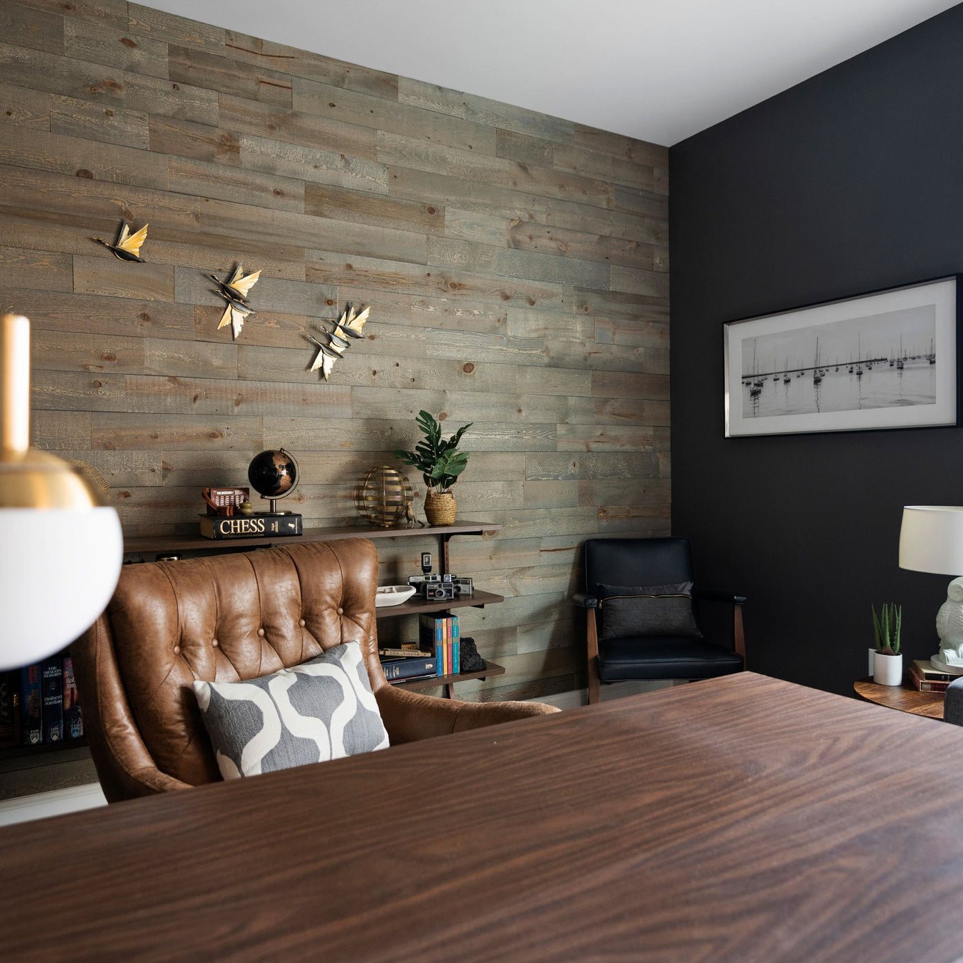 Home office with a wall of Graystone Peel & Stick Wood Wall Planks behind a brown leather chair