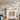 Reclaimed weathered wood planks cover fireplace wall with white mantel and stacked firewood accent