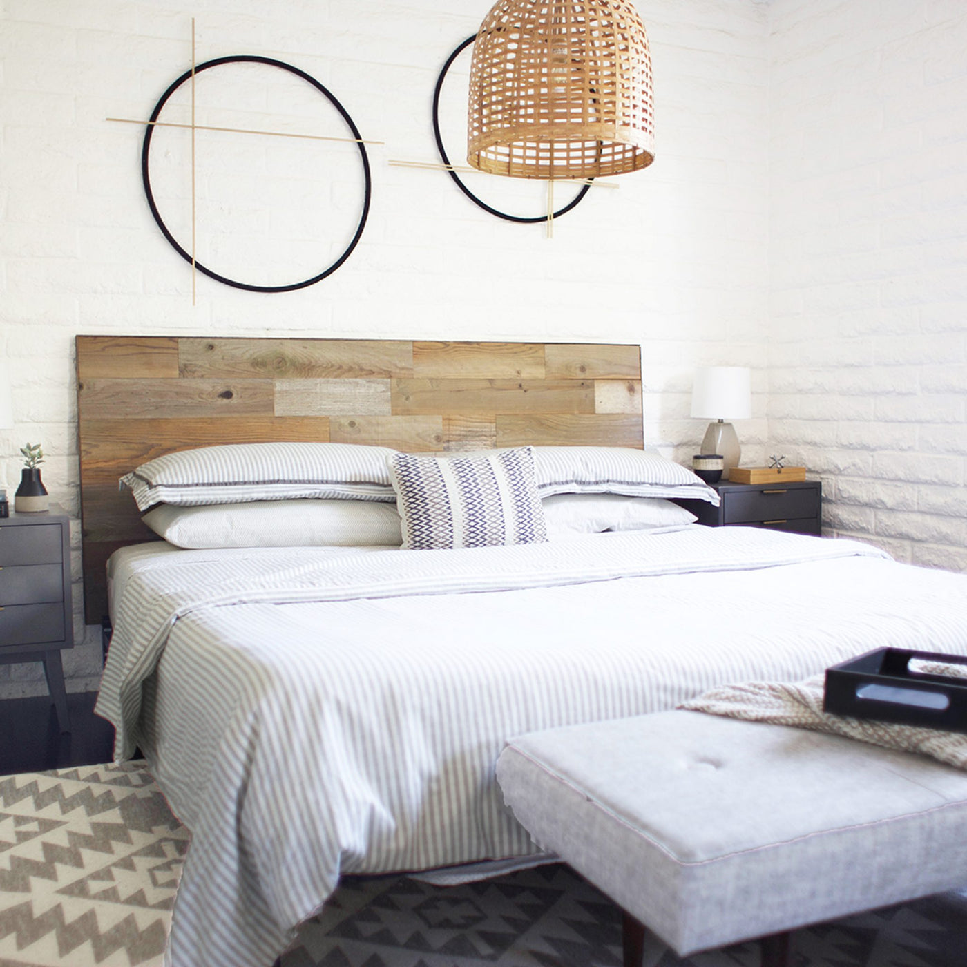 Bedroom with King Size Reclaimed Wood Headboard, striped bedding, and geometric wall art