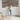 Woman holding peel and stick wood plank while installing a natural wood plank accent wall in a bright room