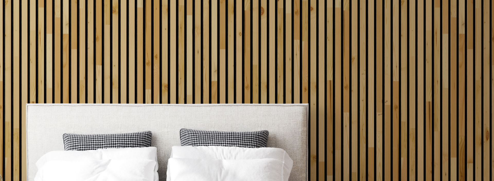 Modern bedroom with natural wood plank peel and stick feature wall behind a light fabric headboard and pillows