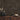 Gunstock mosaic wood tiles on a wall above a wood cabinet with vases and a bowl