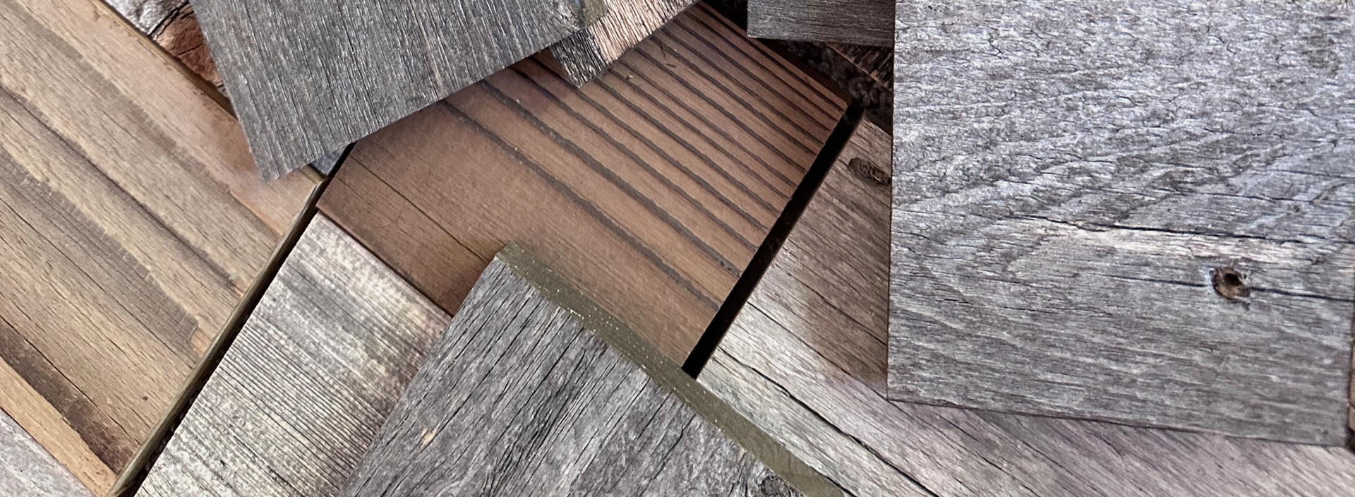 Various natural wood plank samples with different tones and textures arranged overlapping on a surface