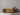 Minimalist wooden sideboard with slatted doors against plain light gray wall and simple decor on top