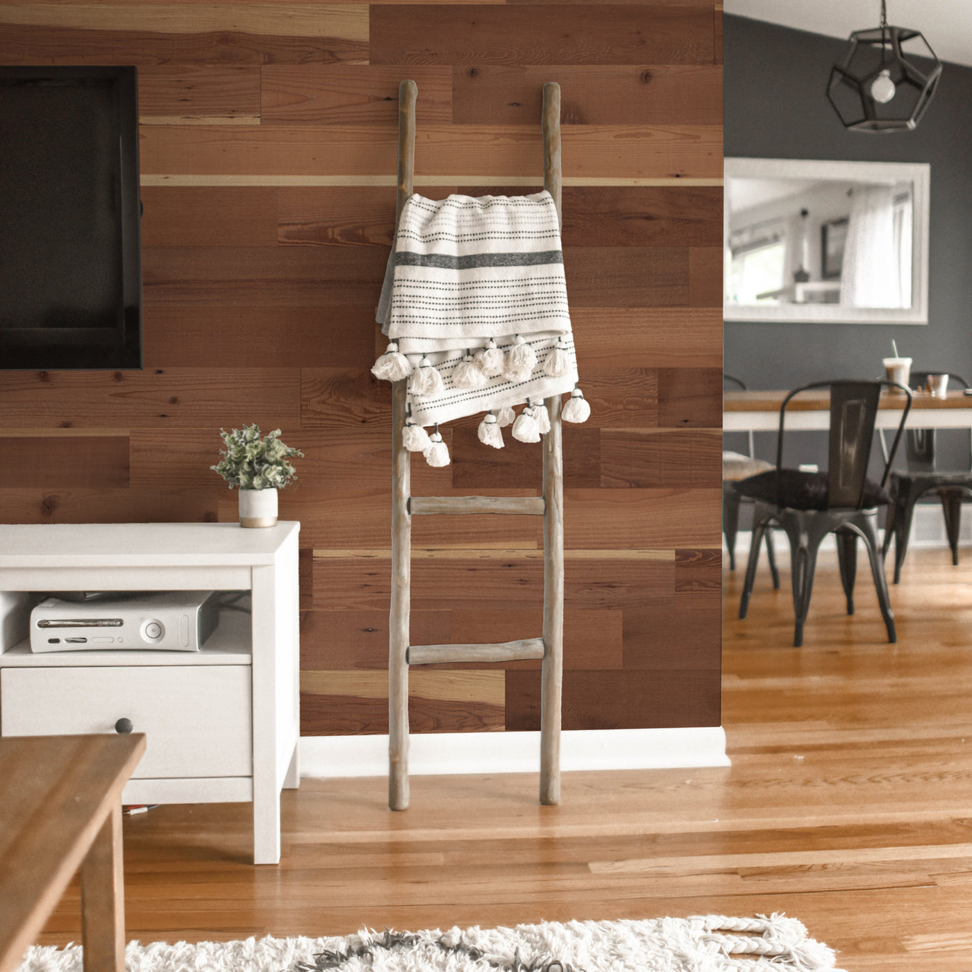 redwood grove peel & stick wood planks in living room behind tv and blanket ladder